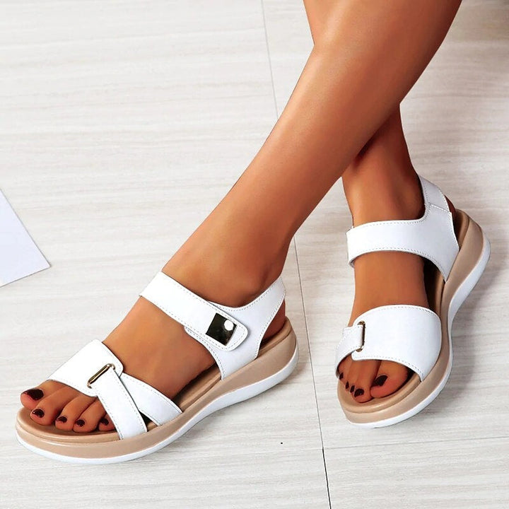 Chanda women's white open-toe back strap sandals with wide front straps, buckle details, and a low platform sole.