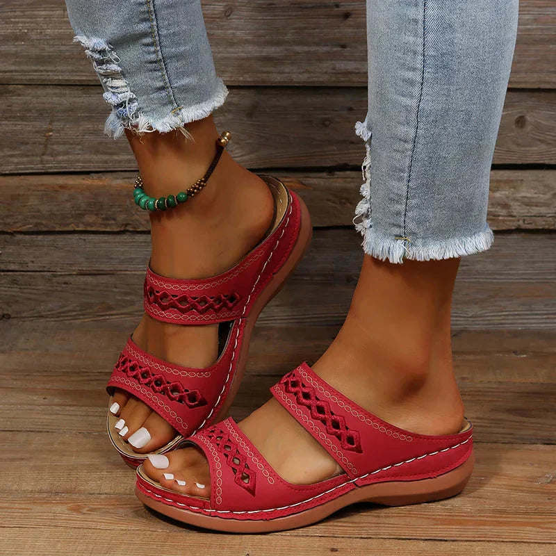 Women's Ezra red open-toe slip-on wedge sandals with cutout straps, worn with distressed jeans.