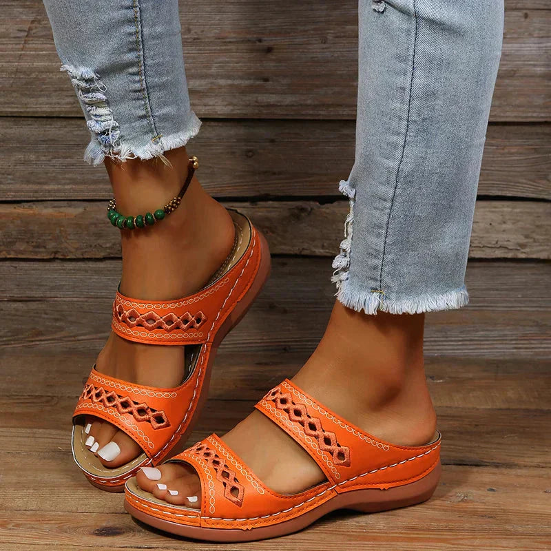 Ezra women's orange open-toe slip-on wedge sandals with cutout strap detailing, paired with distressed jeans.