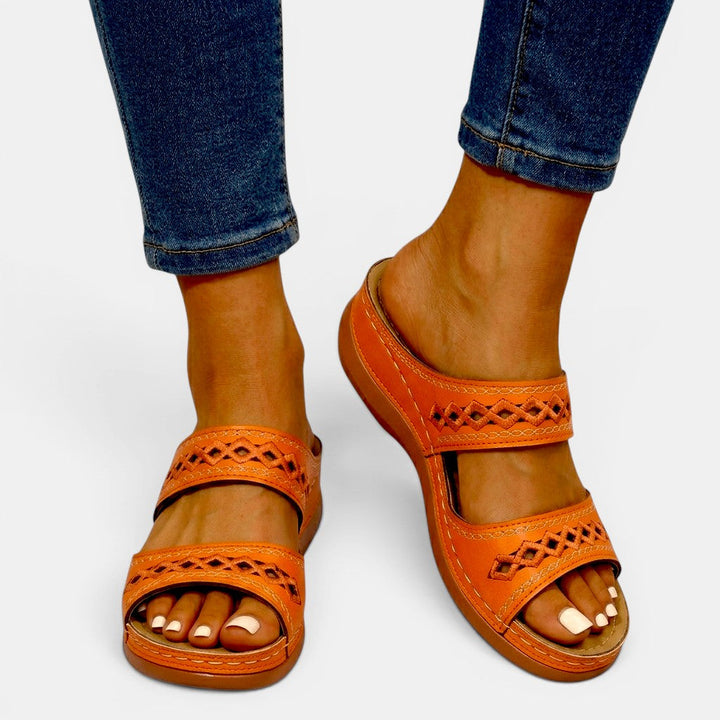 Mia women's orange double strap orthopedic slide sandals with cutout detailing and cushioned sole.
