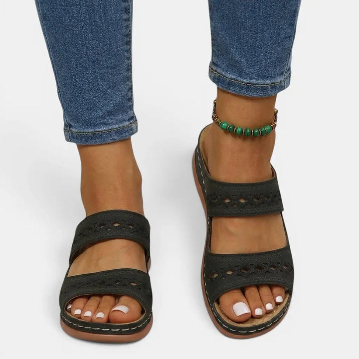 Mia women's black double strap orthopedic slide sandals with cutout detailing and cushioned sole.