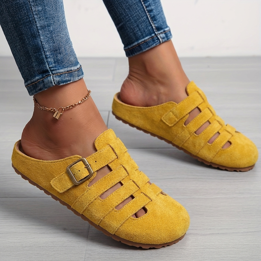 Nora women's yellow suede buckle strap slip-on mule sandals with closed toe and airy cutouts.