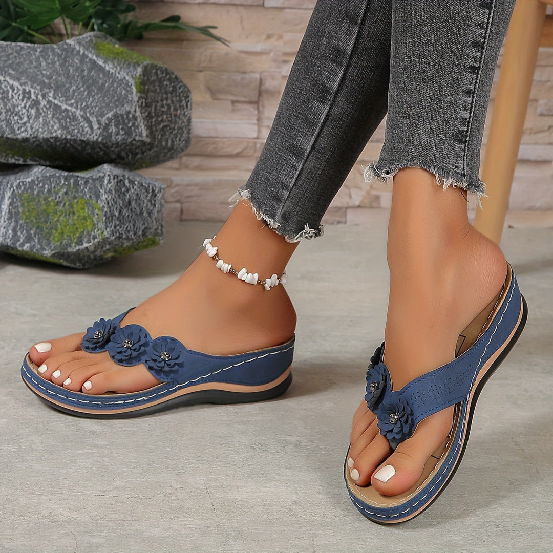 Women's Pippa blue floral slide sandals with layered flower details, contrast stitching, and a low sole.