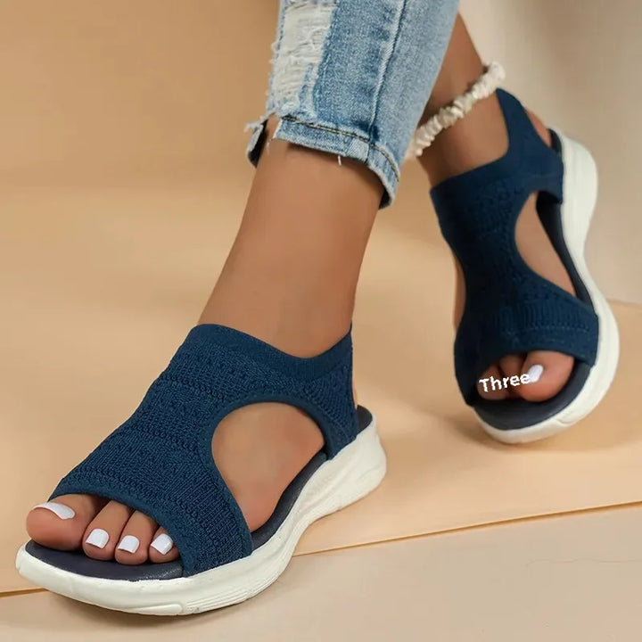 Women's Soleil navy knit slip-on sandals with an open toe, side cutouts, and a cushioned white sole.