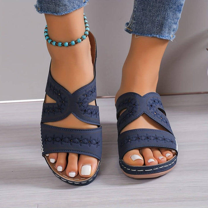 Women's Soleva navy embroidered wedge slide sandals with side cutouts, perfect for summer style.