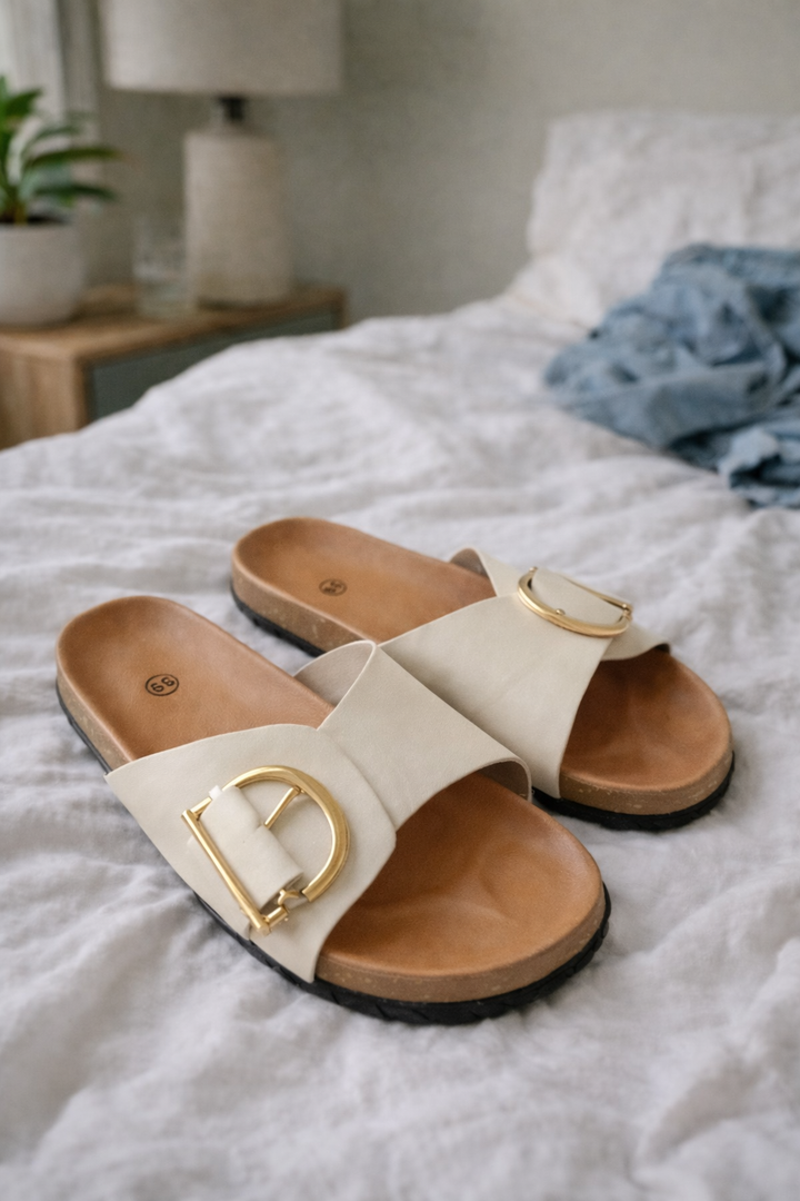 Sylvie women's buckle slide sandals in cream with a wide strap, open toe, and gold-tone buckle detail.