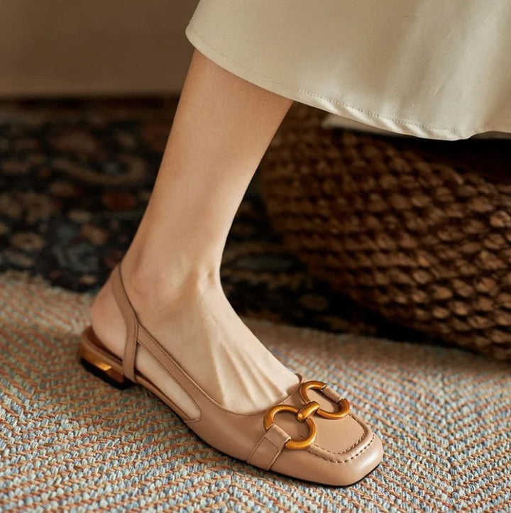 Verena women's nude slingback buckle flats with a closed toe, low flat heel, and gold-tone buckle detail.