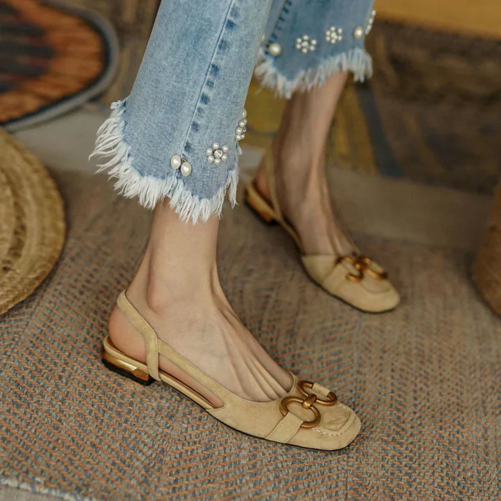 Verena women's beige suede slingback flats with a closed toe, low flat heel, and gold-tone buckle detail.