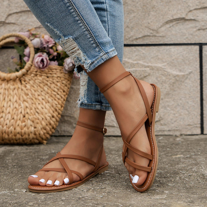 Zayra women's brown ankle strap flat sandals with slim crisscross straps, perfect for effortless summer style.