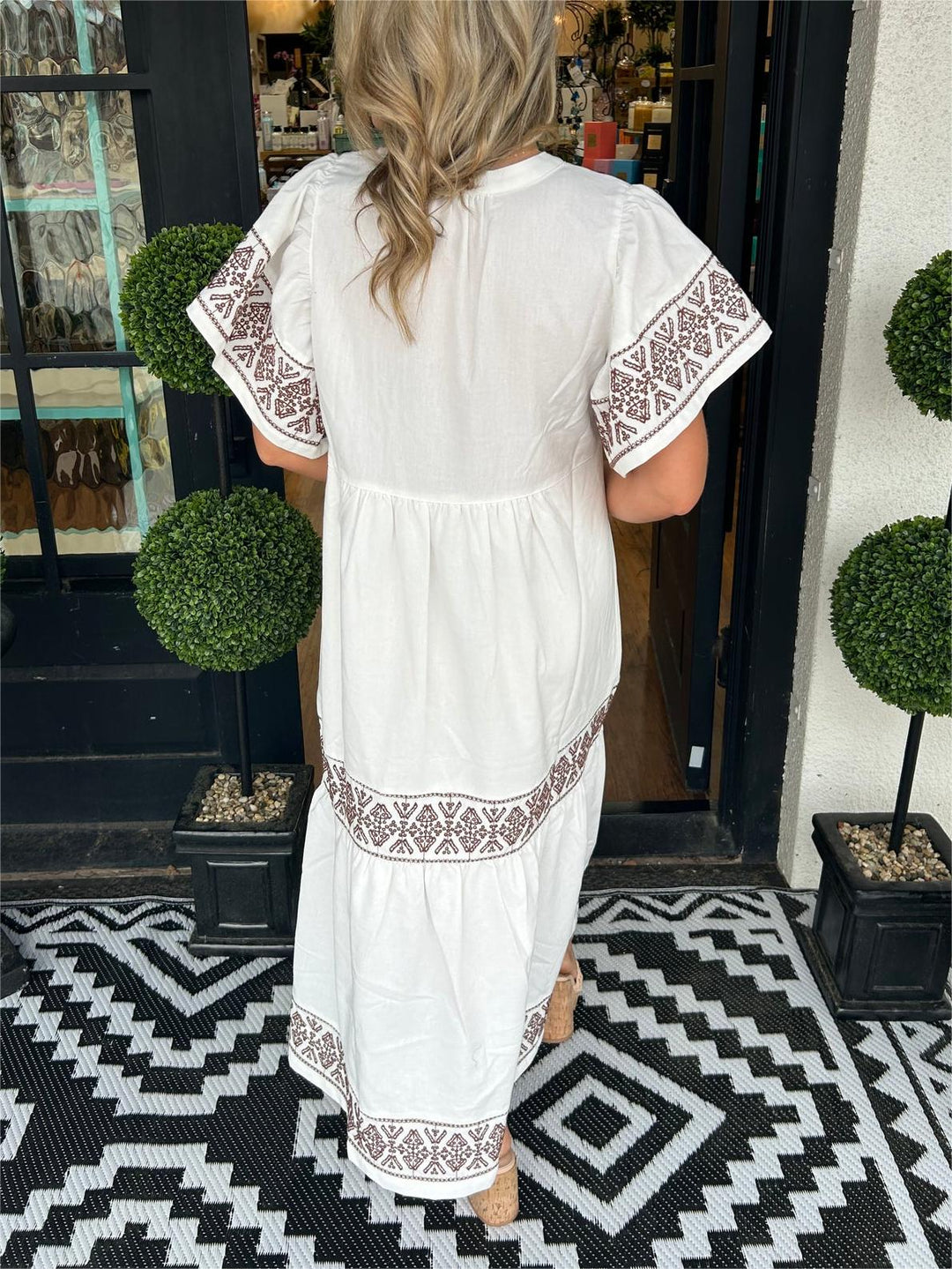 Woman from behind in white Abigail boho midi dress with brown embroidered trim.