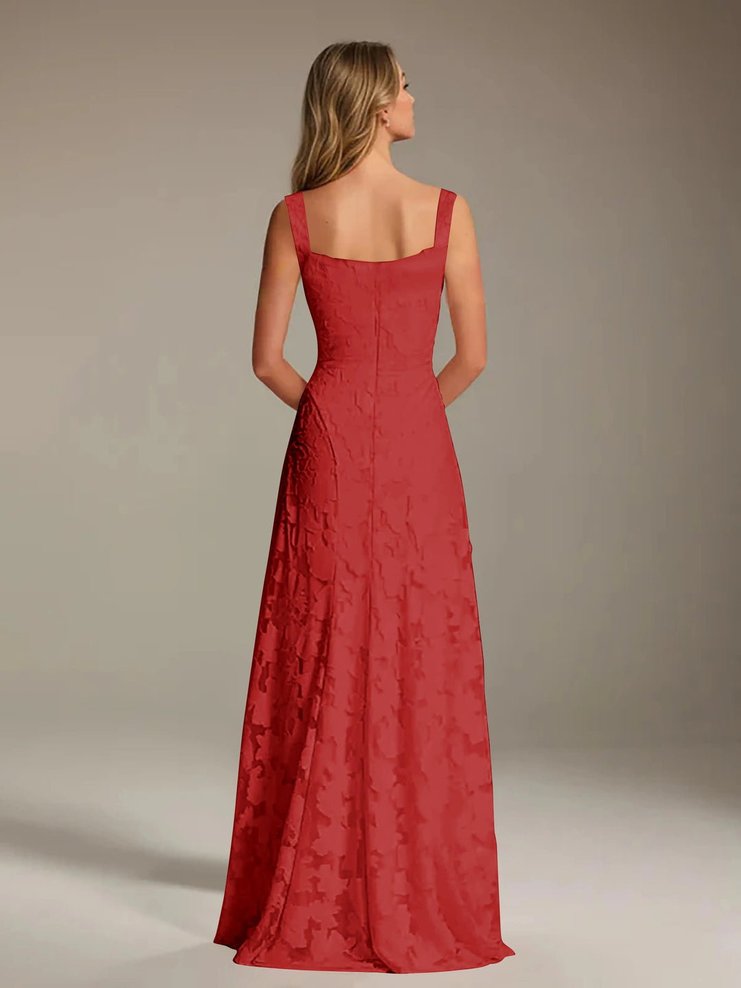 Woman from behind in a red floral lace A-line bridesmaid dress with a square neckline.