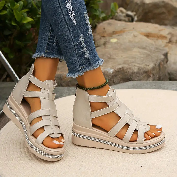 Anika women's beige platform gladiator sandals with strappy upper, open toe, and rhinestone-detailed sole.