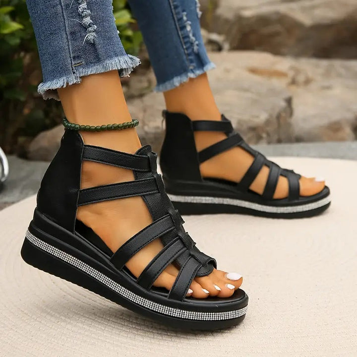 Black platform gladiator sandals with strappy upper, open toe, and rhinestone trim.