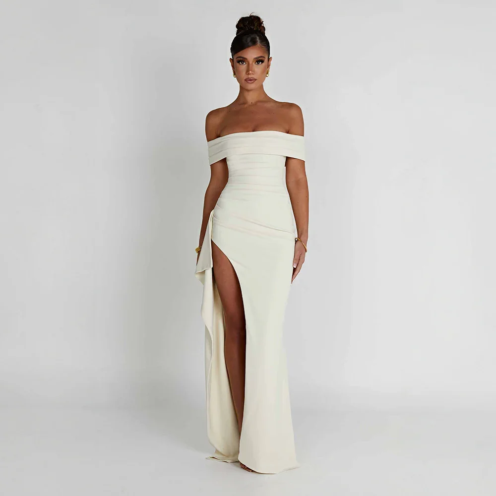 White Bria off-shoulder maxi dress with high slit, flowing fabric.