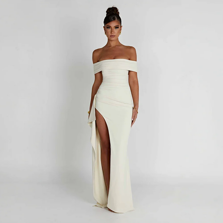White Bria off-shoulder maxi dress with high slit, flowing fabric.