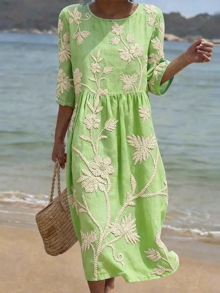 Charlene women's light green vintage floral embroidered midi dress with three-quarter sleeves, worn on a beach.