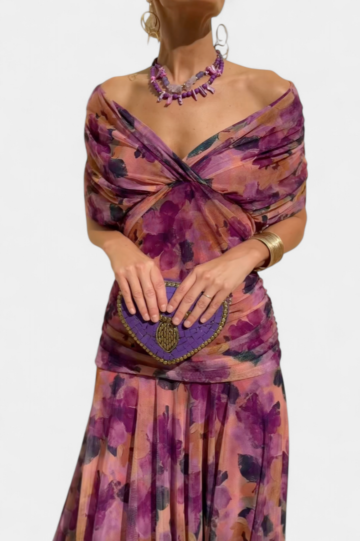Purple floral off-shoulder maxi dress with a ruched waist, flowing skirt, and short sleeves.