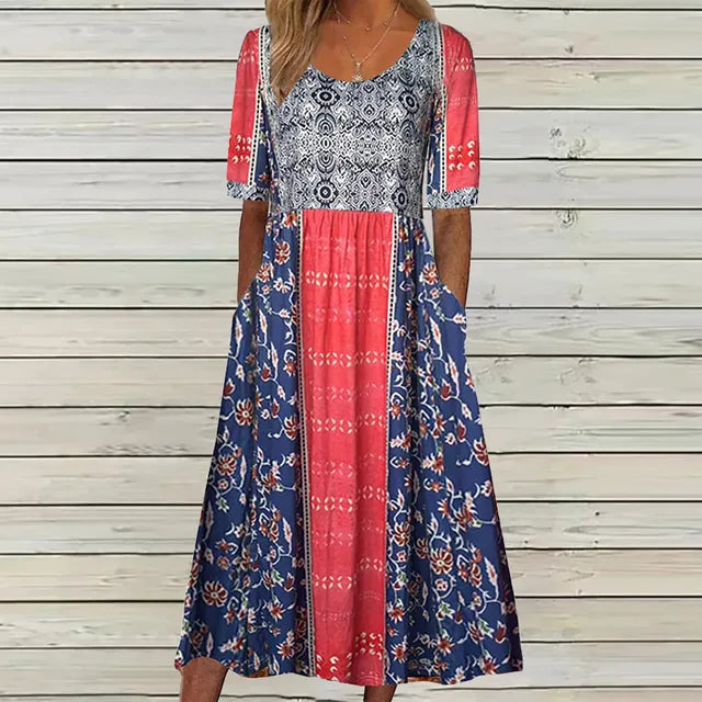 Women's square neck boho midi dress with blue floral, coral, and white patterned panels, short sleeves, and pockets.