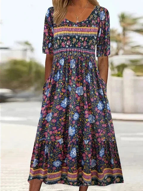 Women's navy boho midi dress with colorful floral print, square neck, shirred bodice, and tiered skirt.