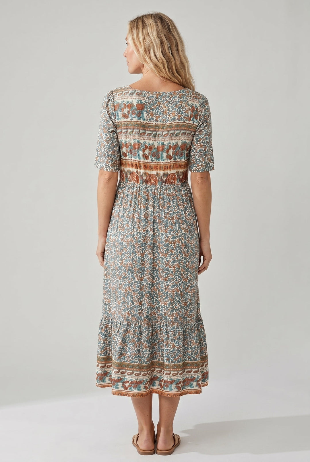 Woman in a Dahlia boho printed midi dress with a square neck, shirred bodice, and tiered skirt.