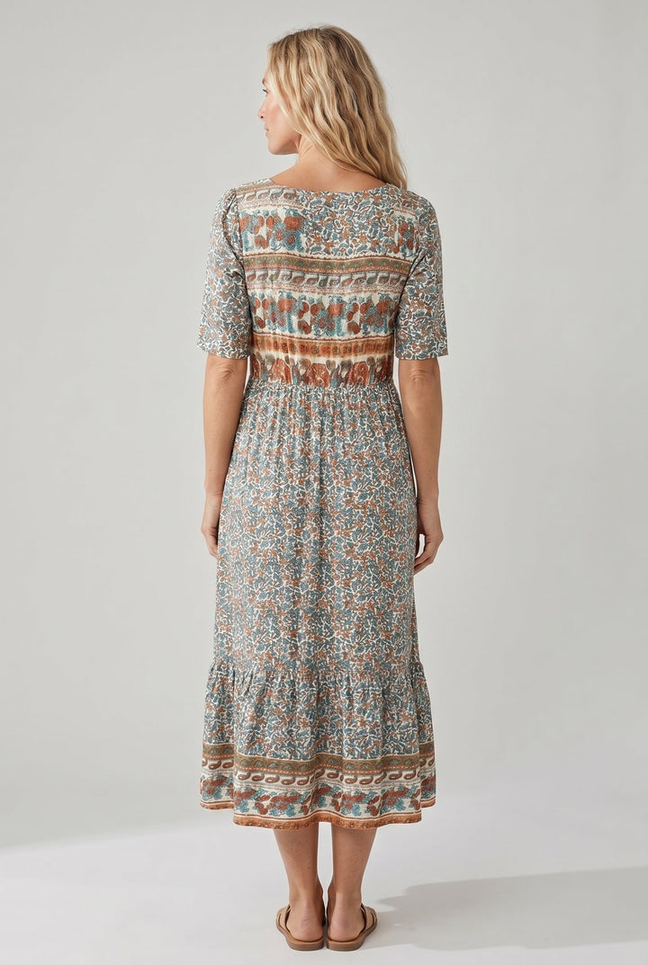 Woman in a Dahlia boho printed midi dress with a square neck, shirred bodice, and tiered skirt.