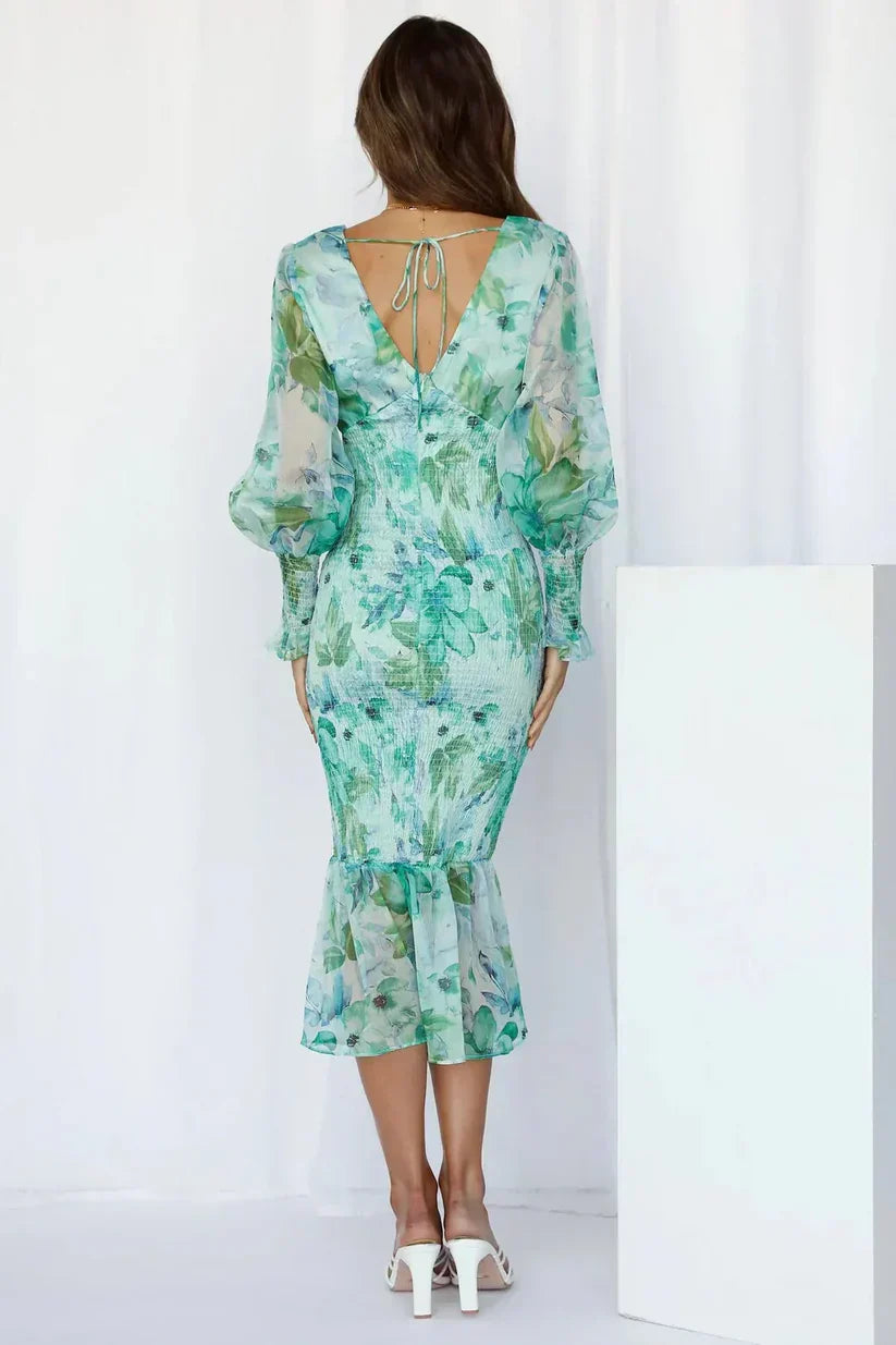 Davina women's floral smocked V-neck midi dress in green with sheer long sleeves and ruffle hem.