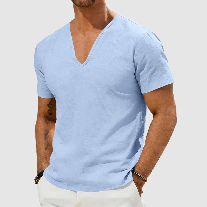 Men's light blue Declan short sleeve linen V-neck shirt, worn with white trousers.