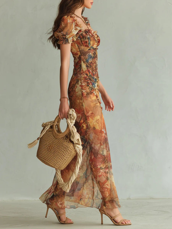 Woman in a flowing Edelyn chiffon boho dress with a sweetheart neckline, ruffles, and a floral print, holding a woven bag.