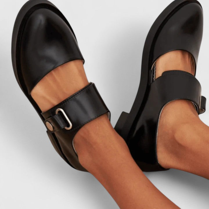 Women's black leather Mary Jane shoes with a buckle strap and low heel.