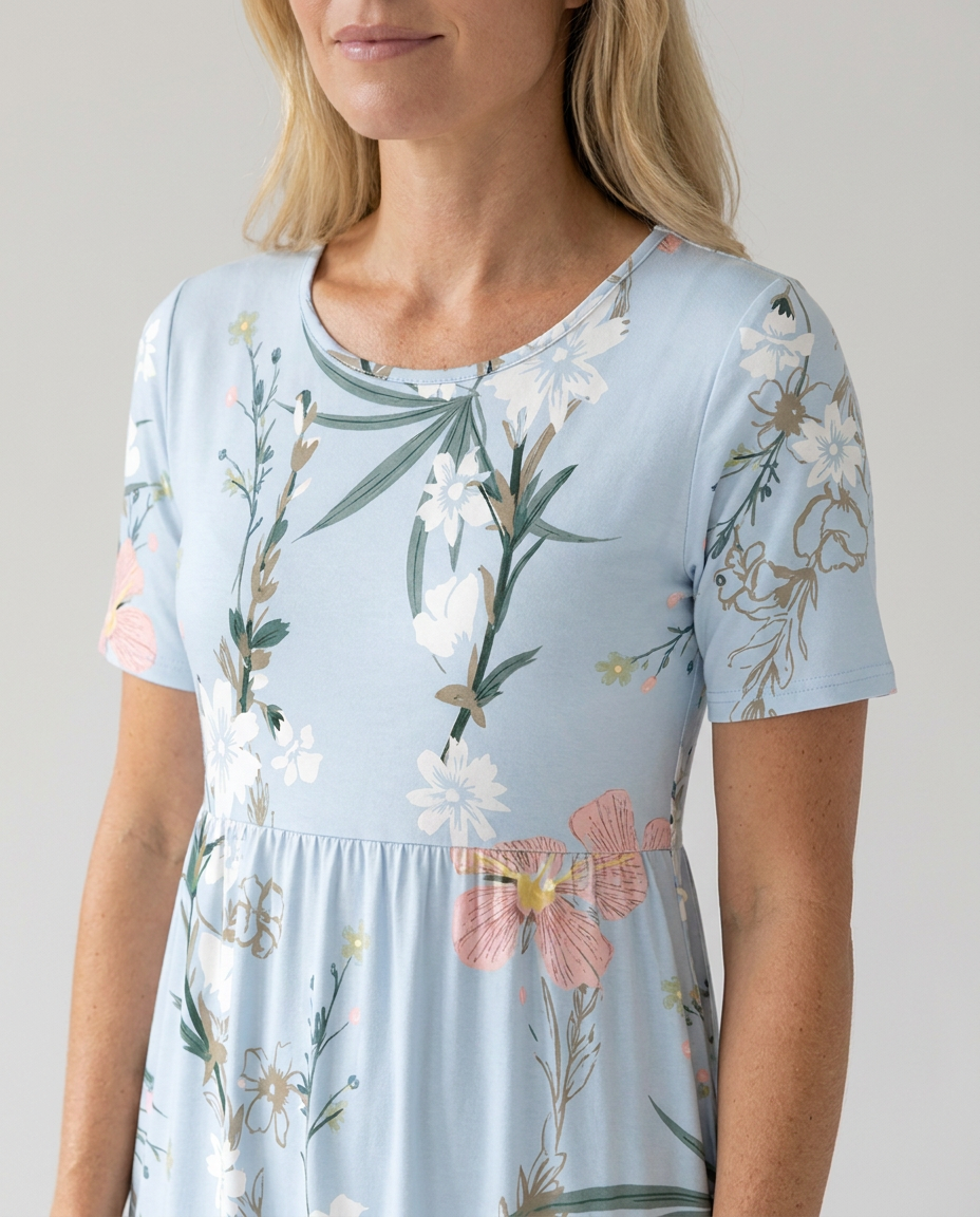 Women's Grace short sleeve midi dress in light blue with a vibrant floral print, round neckline, and gathered waist.