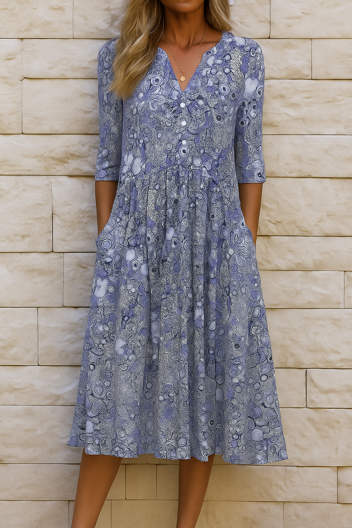 Blue women's printed midi dress with V-neck, 3/4 sleeves, and flowing skirt.
