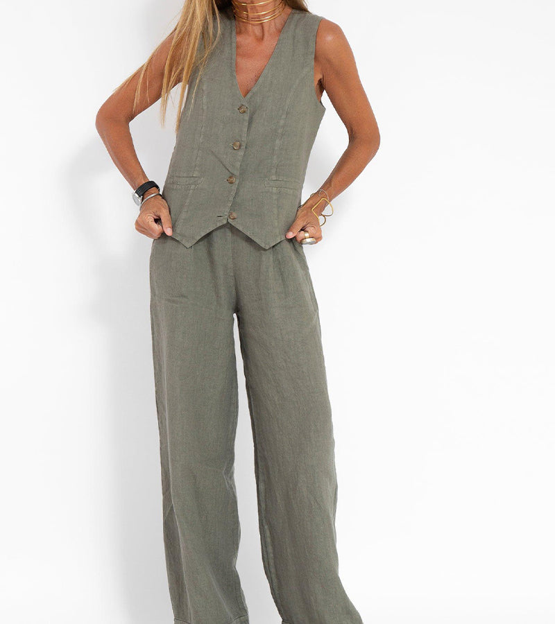 Woman wearing a Jhoana olive green linen vest with V-neck and wide-leg pants.