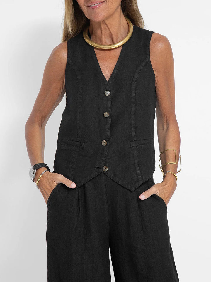 Woman wearing a black linen vest and wide-leg pants set with a V-neck and button front.