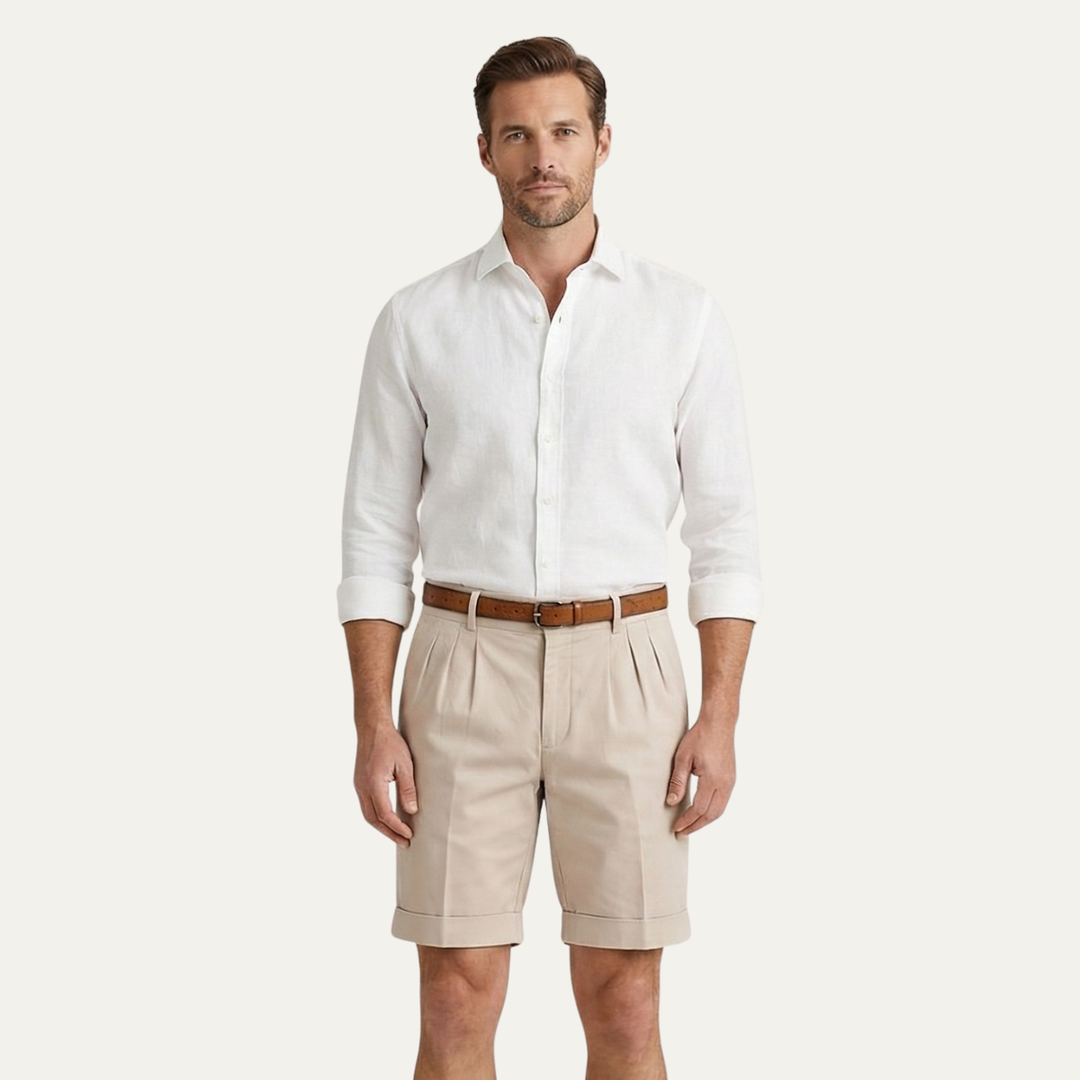 Men's Julian pleated chino shorts in light tan, with cuffed hems and a brown belt.