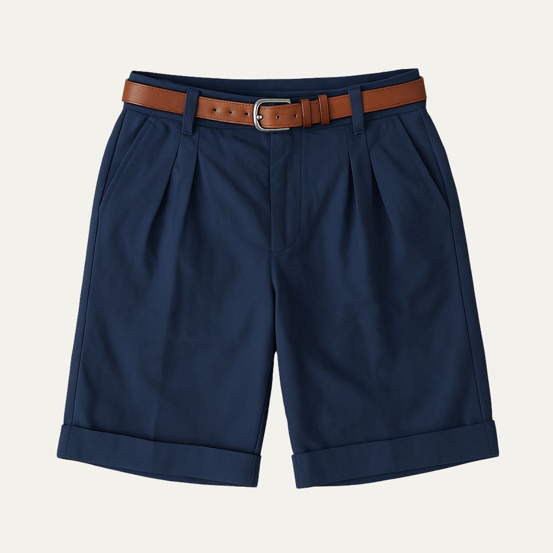 Men's Julian navy pleated chino shorts with a brown leather belt, cuffed hems, and side pockets.