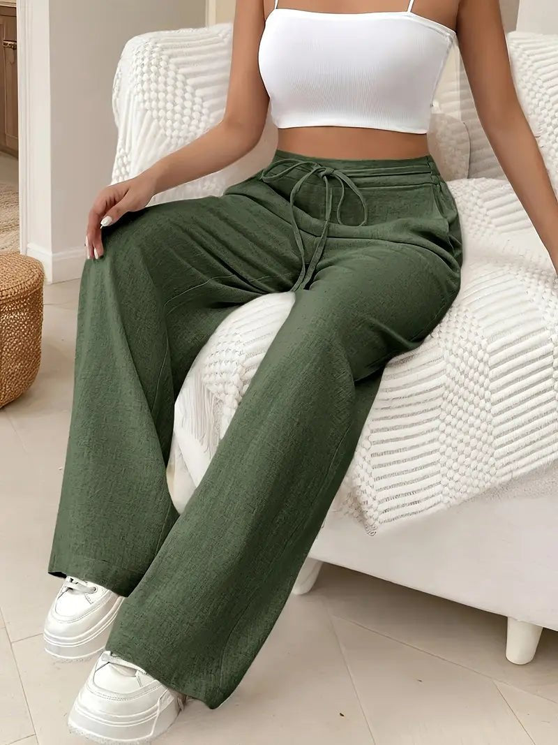 Woman wearing Keira olive green linen wide-leg pants with a drawstring waist and side pockets, paired with a white crop top.