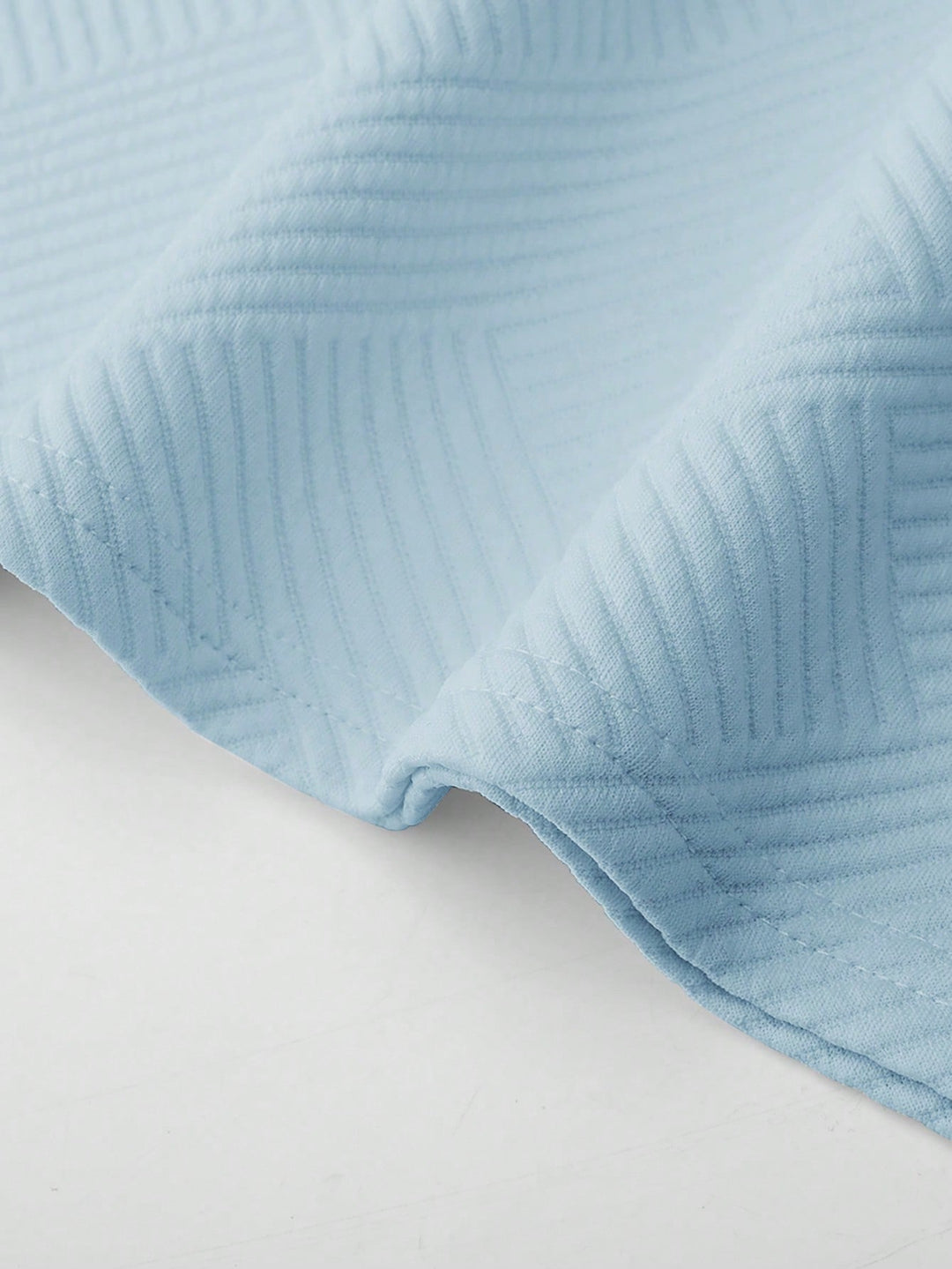 Close-up of light blue textured fabric from the Landon men's t-shirt and shorts set, showing subtle tonal pattern.