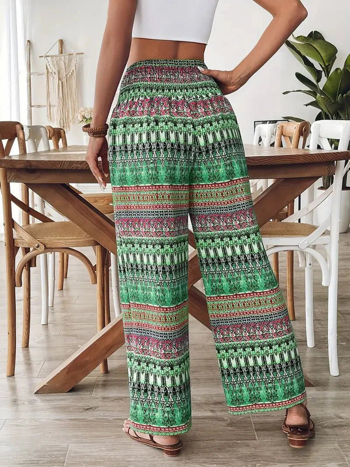 Women's Lyra boho print wide leg pants with a colorful green, pink, and black pattern, drawstring waist.