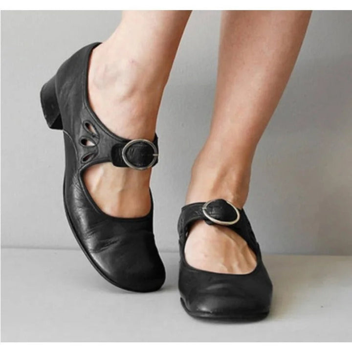 Black leather orthopedic wedge sandals with buckle strap.