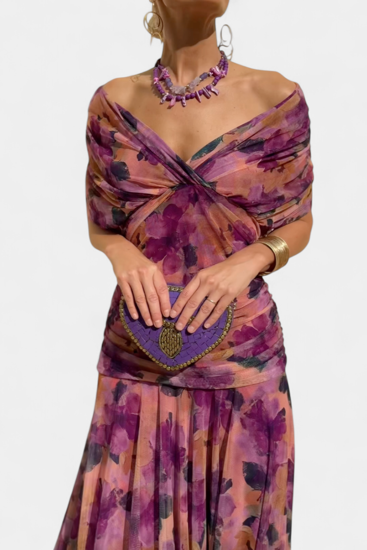 Purple off-shoulder ruched maxi dress with sheer sleeves, made from a flowing fabric.