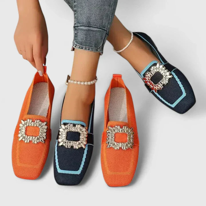 Black leather orthopedic loafers with a gold statement buckle, designed for women.