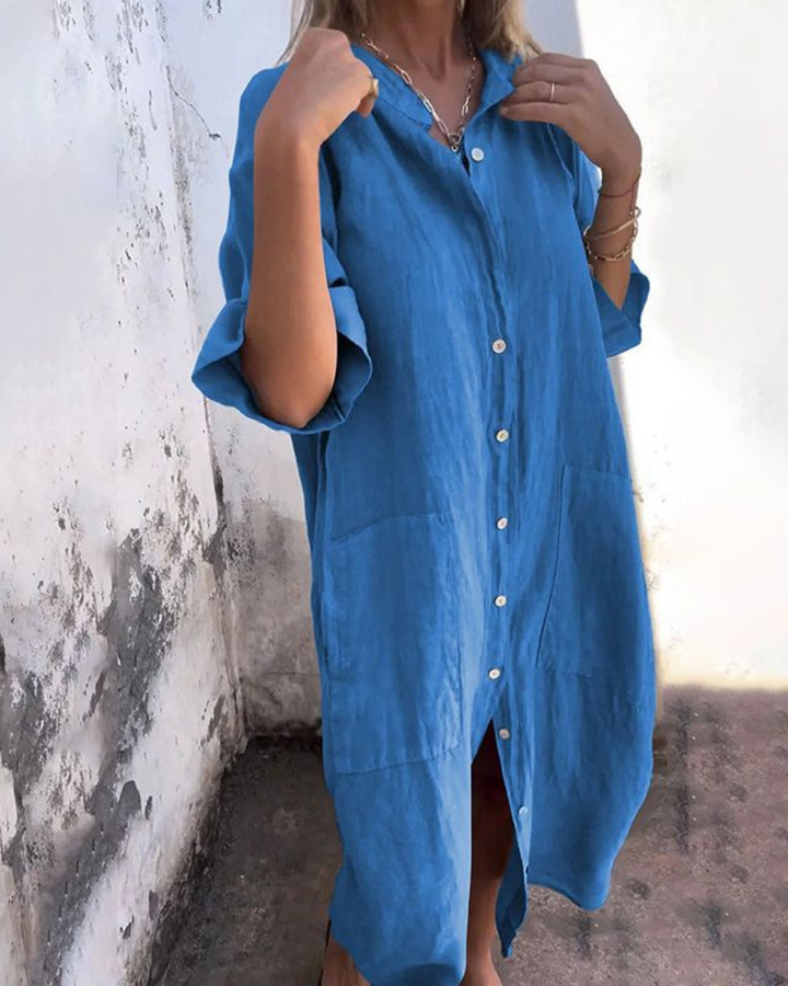 Mina women's plus size blue shirt dress with rolled sleeves, button-front, and front pockets.