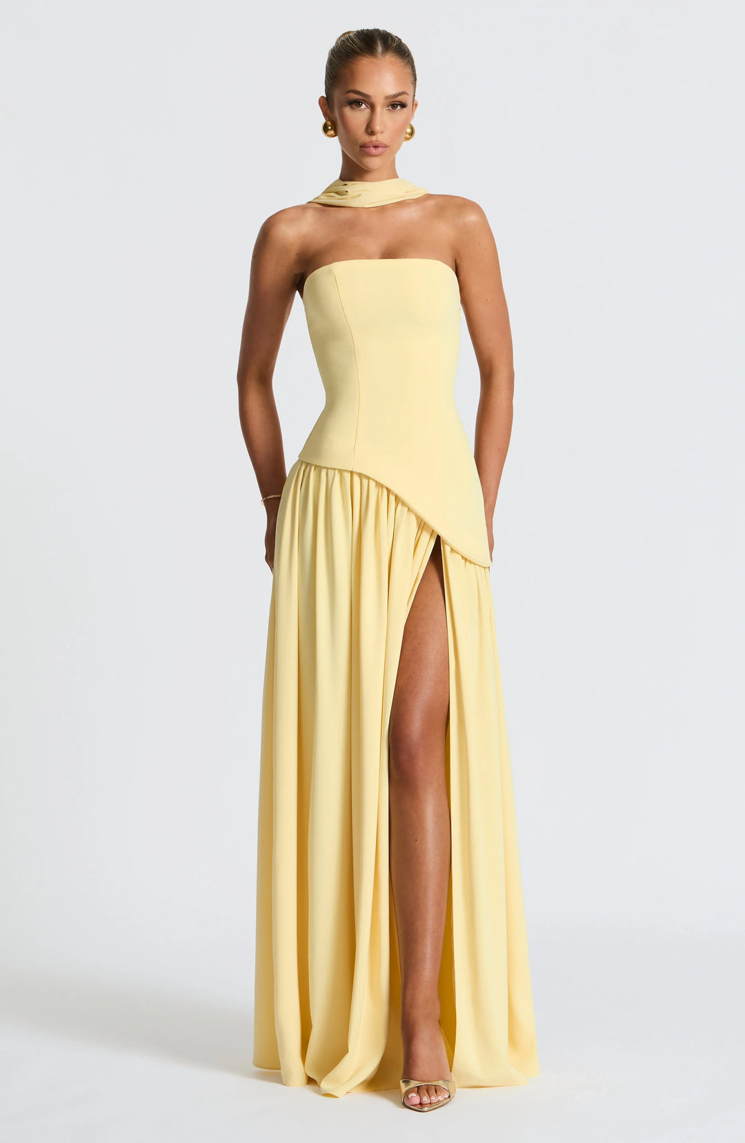 Lemon yellow strapless corset maxi dress with a high slit, made from a flowing fabric.