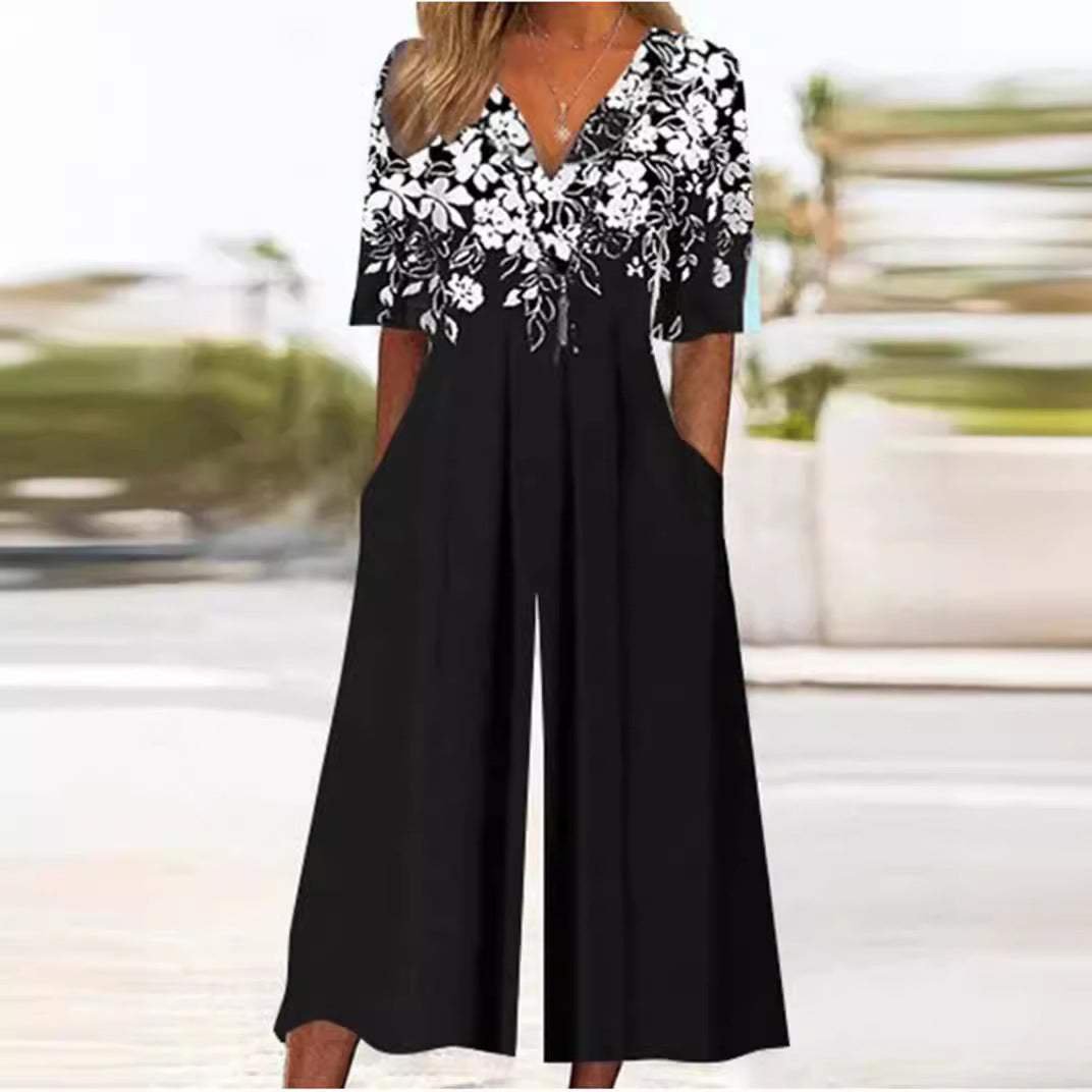 Women's black V-neck wide-leg jumpsuit with white floral print top and half sleeves.