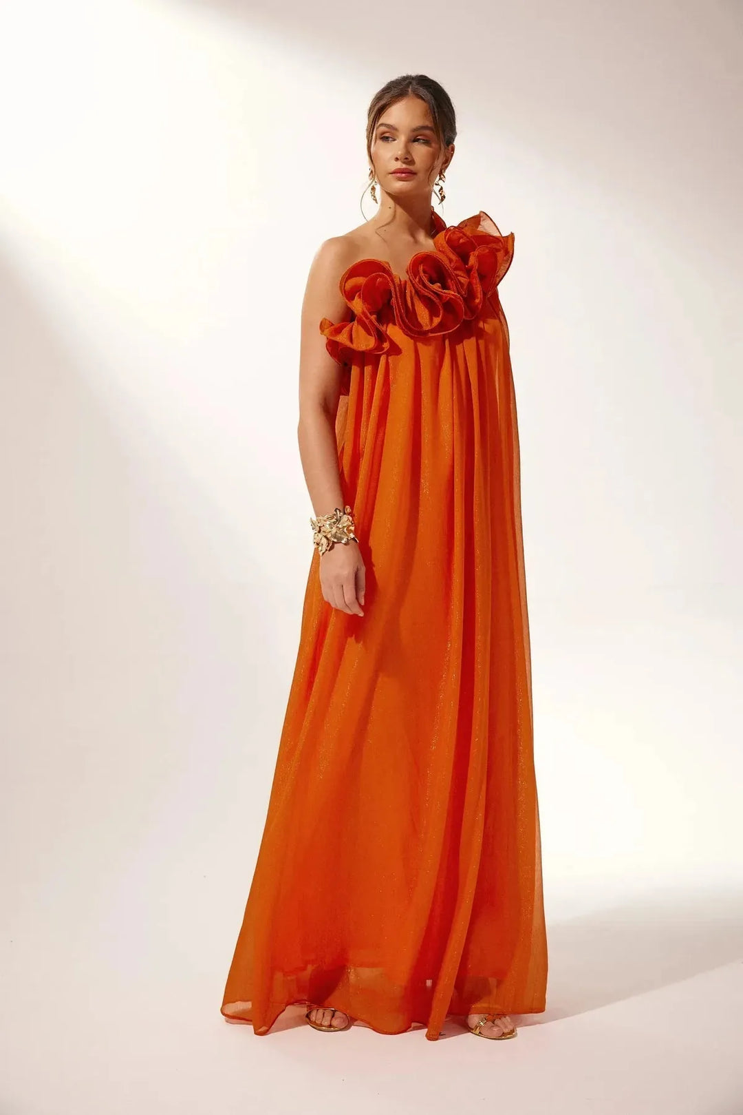 Women's white one-shoulder ruffle maxi dress, flowing fabric.