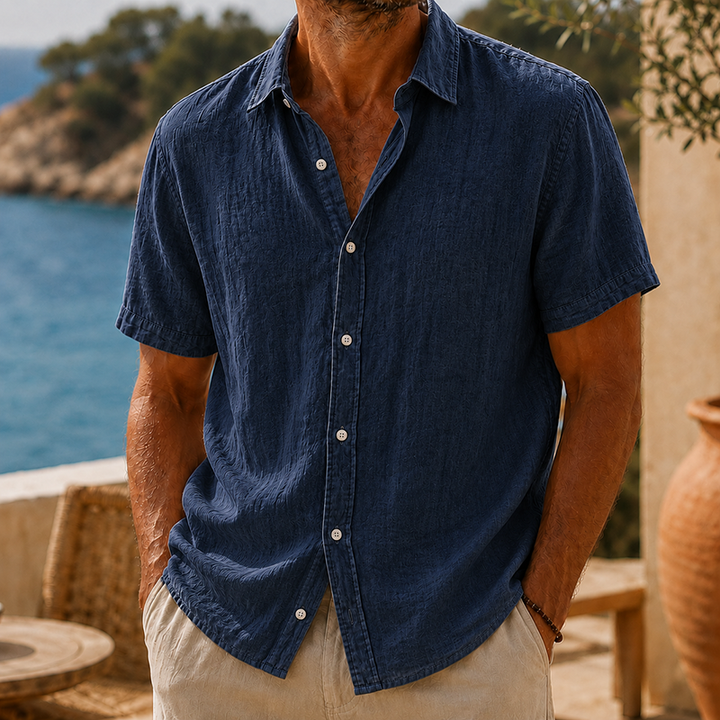Men's navy linen short sleeve button shirt with a collared neckline, worn with khaki pants.