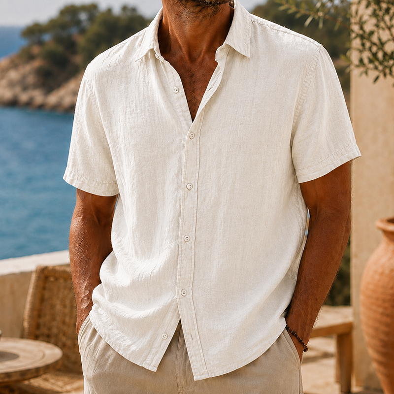 Men's Tyson natural linen short sleeve button shirt with collared neckline, worn with hands in pockets.