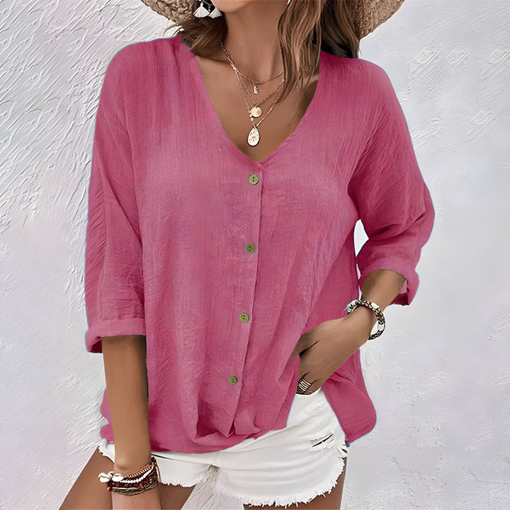 Pink women's V-neck button-up blouse in a soft, flowing fabric.